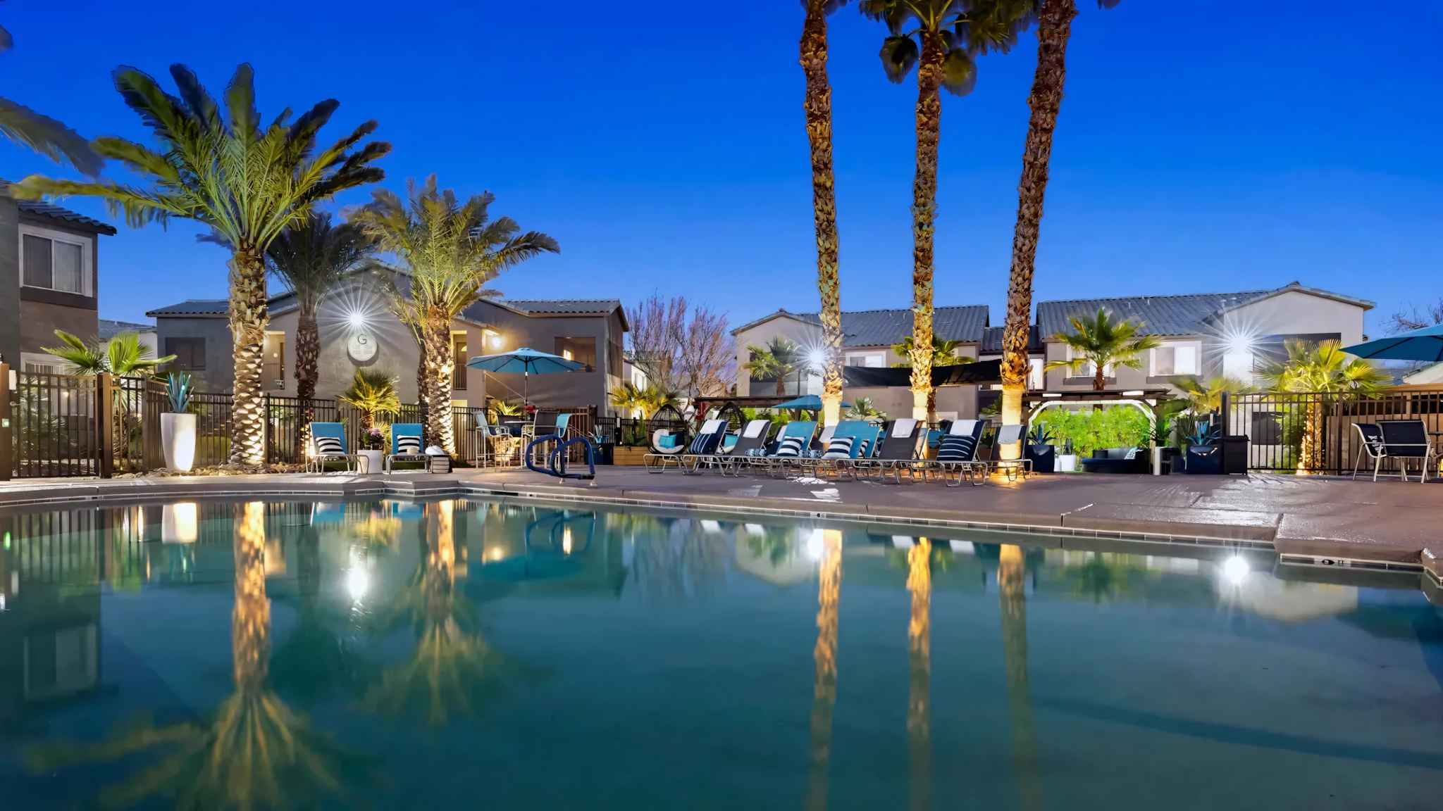 evening view of the community pool and lounge chairs at Millennium East