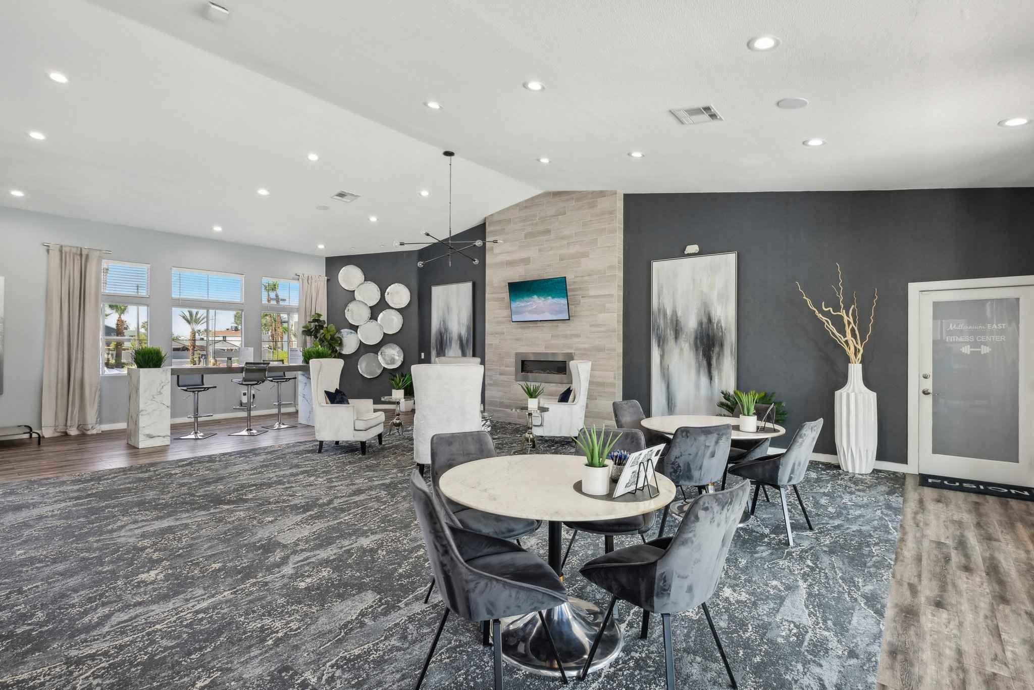 spacious community room with multiple seating options and windows showing outside view at Millennium East